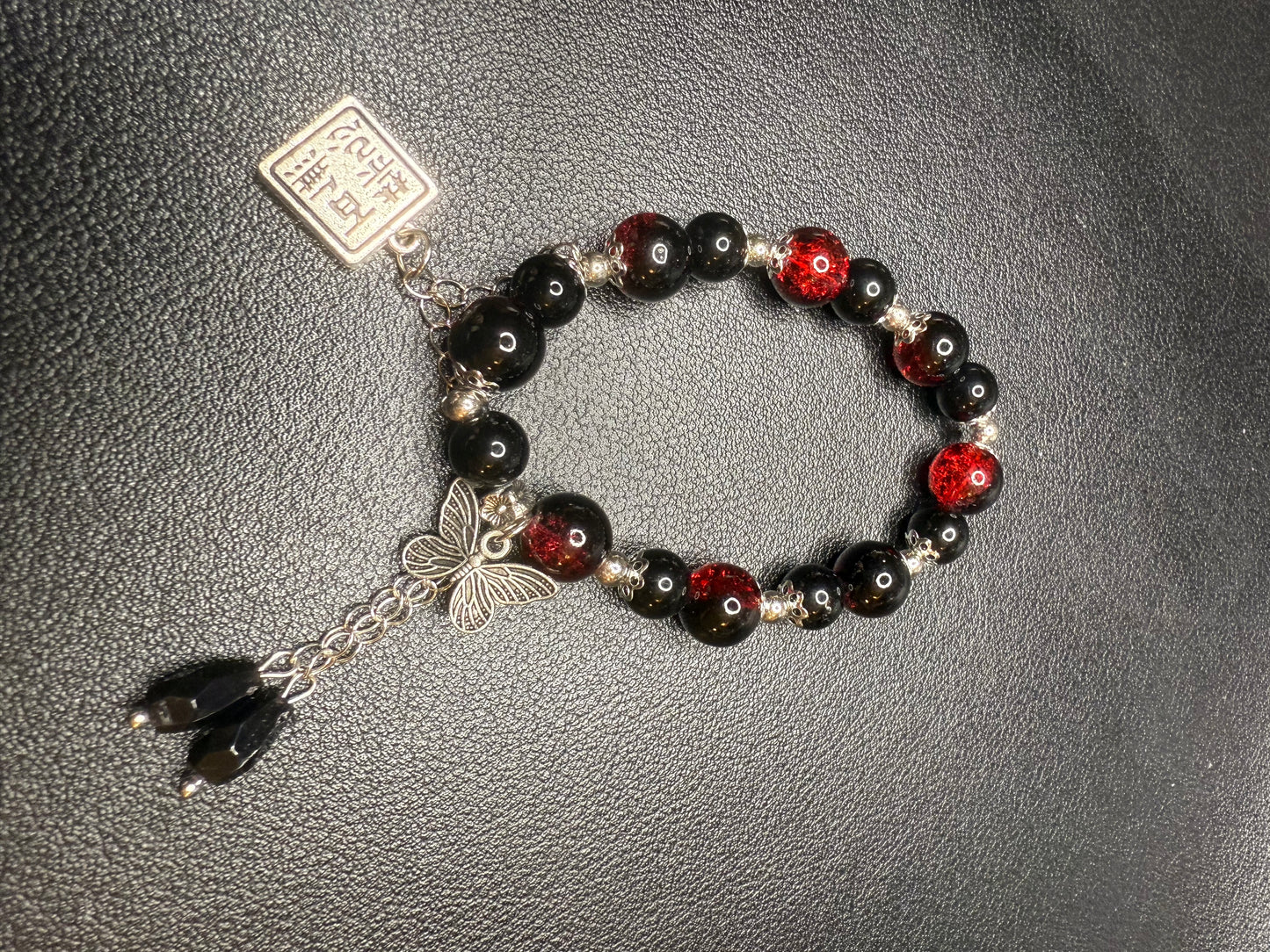 Red glass bead bracelet with metal accents